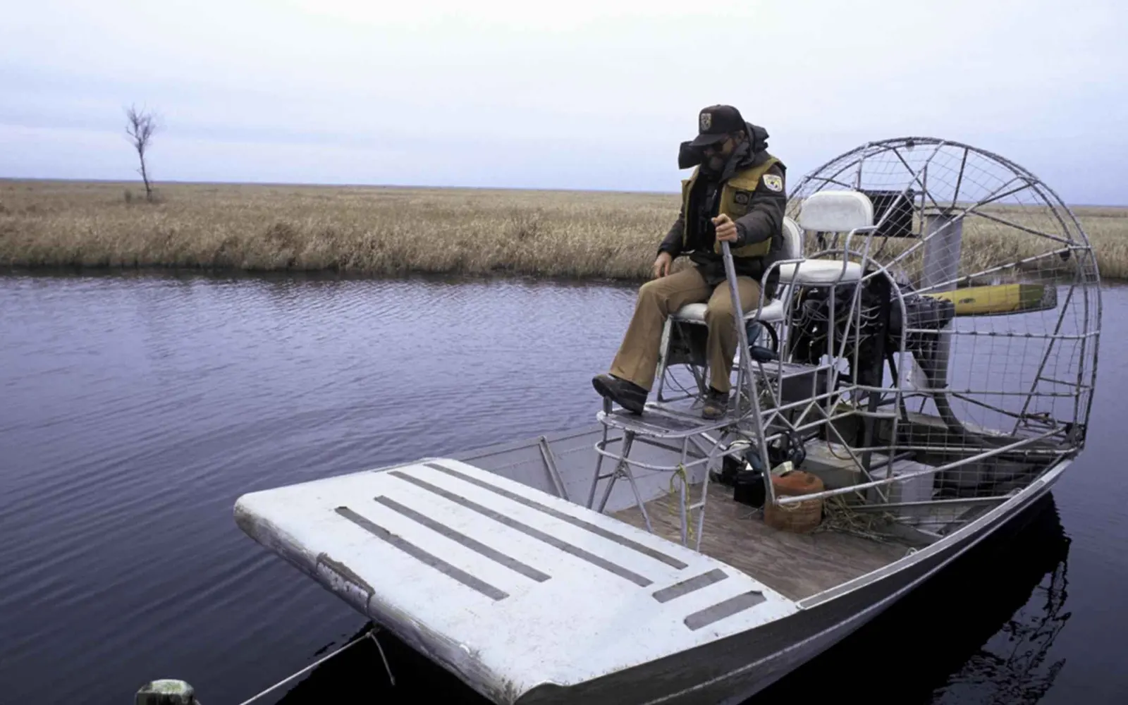 An airboat moving across swamp water during a Louisiana-style tour